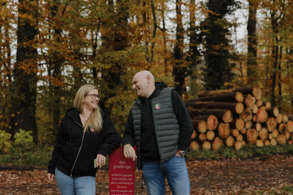 Die beiden Inhaber von kreatiefe im Herbstwald mit einem ihrer individuell gefertigten Gedenkzeichen (Modell „das gradlinige")